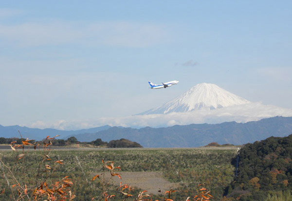 富士山をバックに離陸する全日空機
